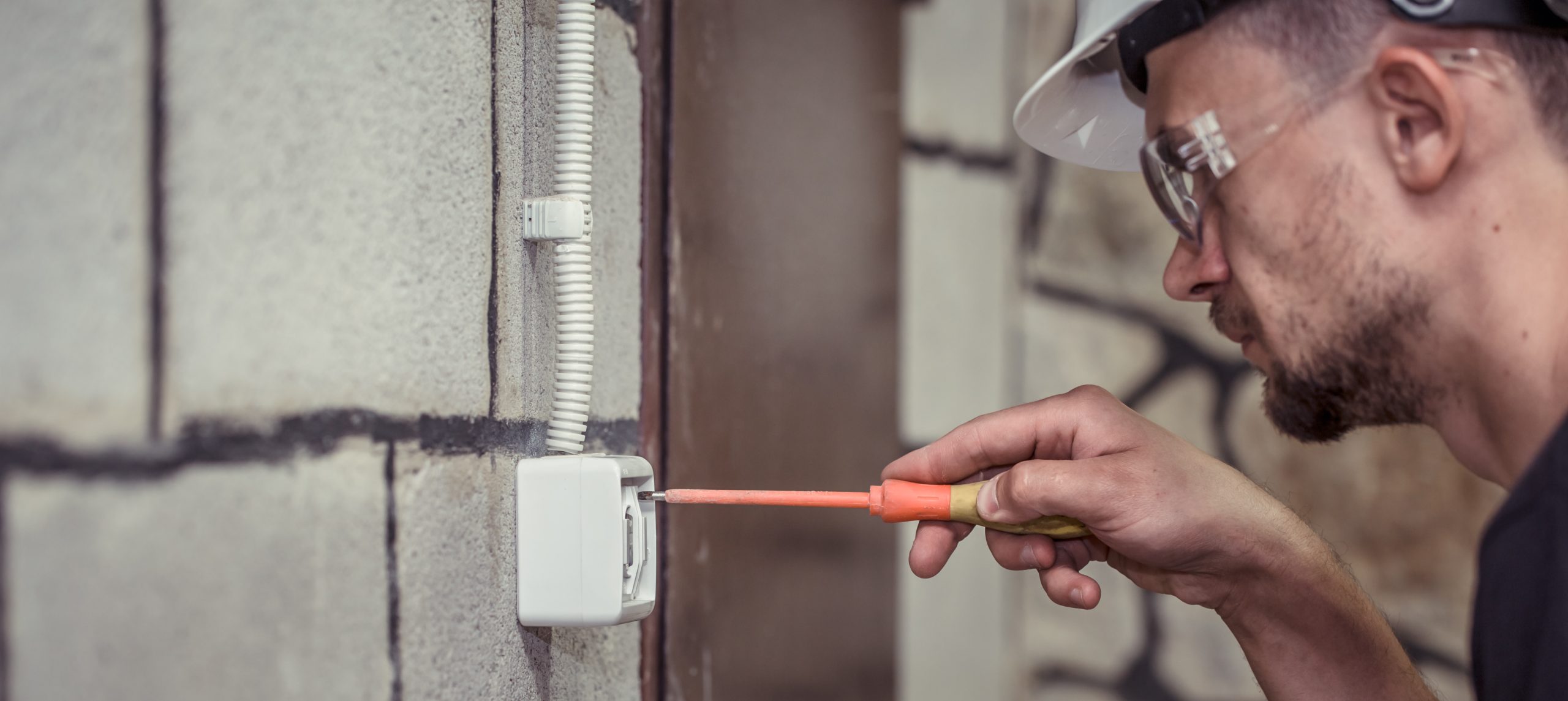 male electrician technician connects equipment with tool